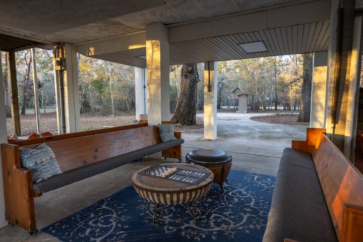 Covered under-house gathering area with seating and drums